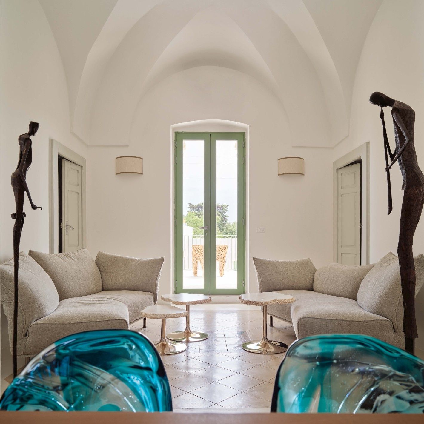 Standalto, Cicladi. In the living room, the soft shapes of sofas in Soft Imperial and tables in alabaster echo the curves of the fa&ccedil;ade staircase. 