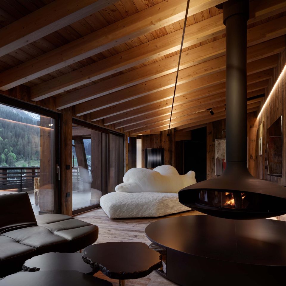  Pack ,  Flap  and  Cicladi . The sofas and tables furnish the living area developed around a large suspended sculpture-fireplace, offering a dual view of the interiors and the landscape. In the background, the Favela armchair on the terrace. 